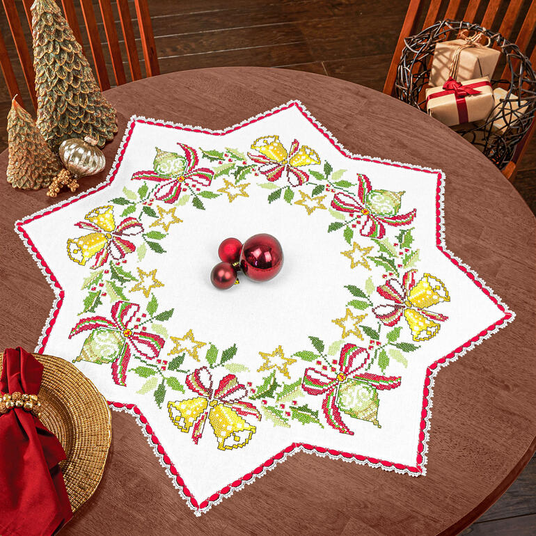 Sternförmige Decke mit Weihnachtsmotiven und Spitze auf einem Tisch