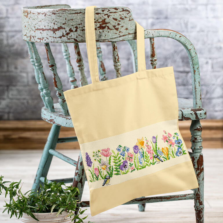 Baumwolltasche mit gestickten Frühlingsblumenmotiven.