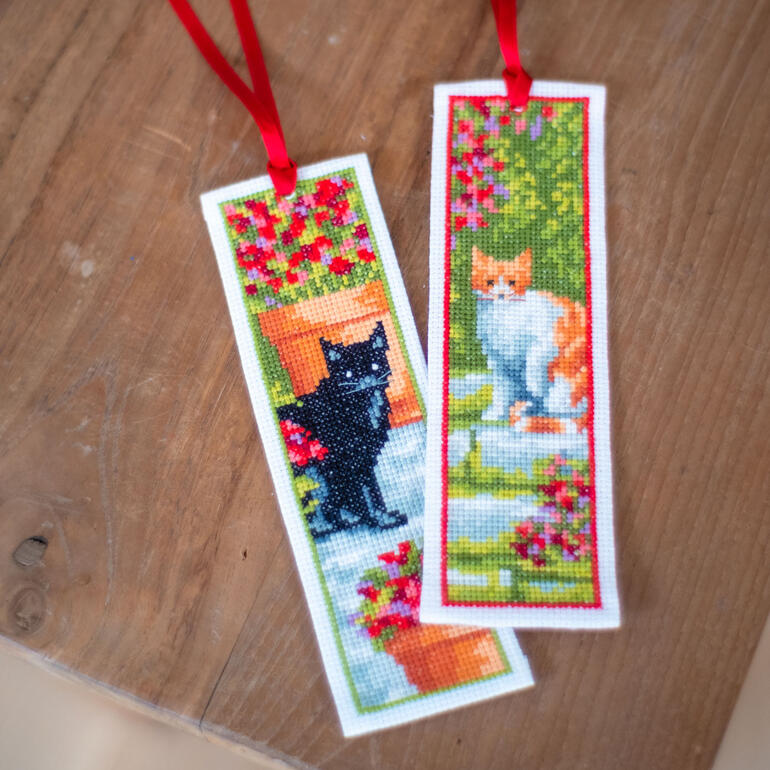 Set mit zwei Lesezeichen mit Katzenmotiven in einem Garten