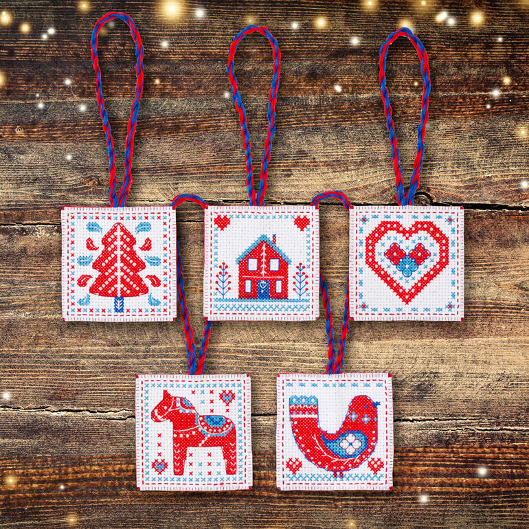 Set aus fünf Weihnachtsanhängern mit verschiedenen festlichen Motiven auf Holzuntergrund.