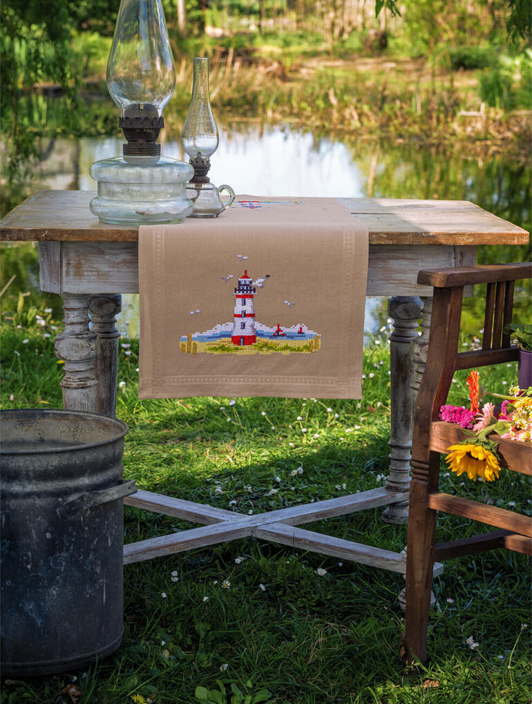 Tischläufer mit einem leuchtenden Leuchtturm-Design im Freien auf einem Tisch.