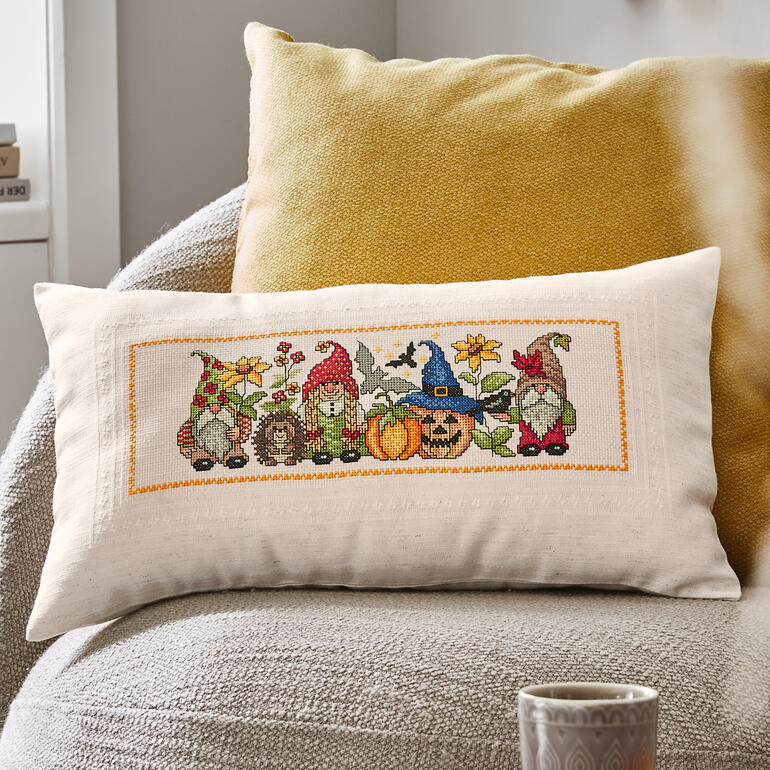 Kissenhülle mit Wichtelmotiven im Herbst, präsentiert in einer gemütlichen Einrichtung.