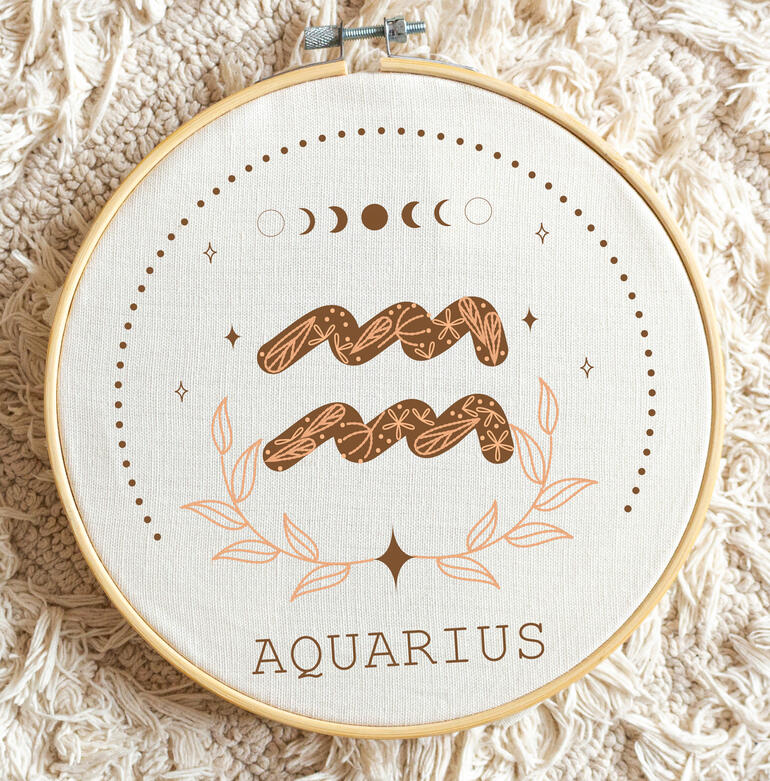 Minimalistische Stickerei des Sternzeichens Wassermann mit grafischen Elementen.