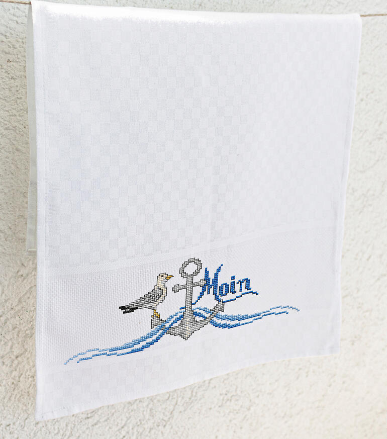 Geschirrtuch mit maritimen Motiven und 'Moin'.
