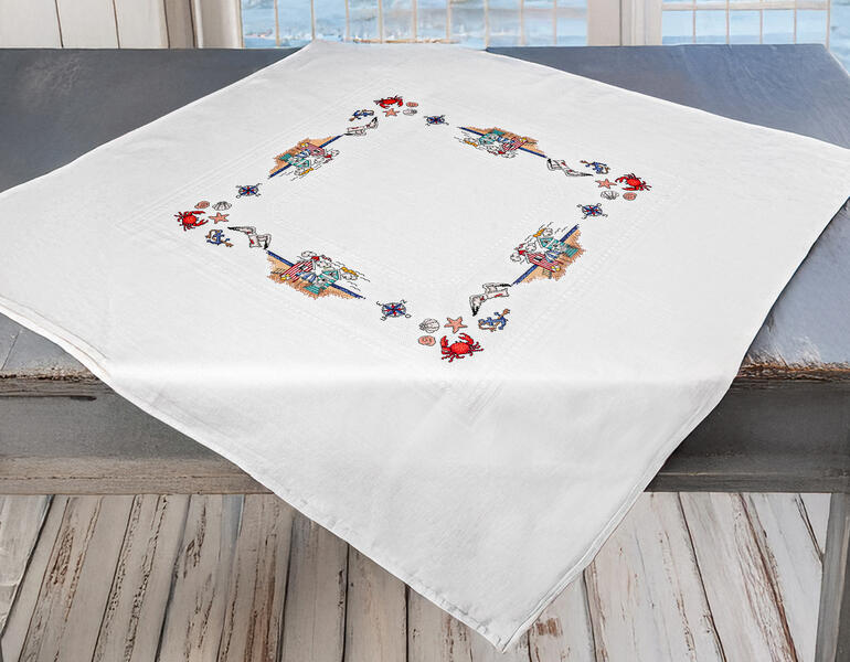 Tischdecke mit maritimen Motiven und Meeressymbolen.
